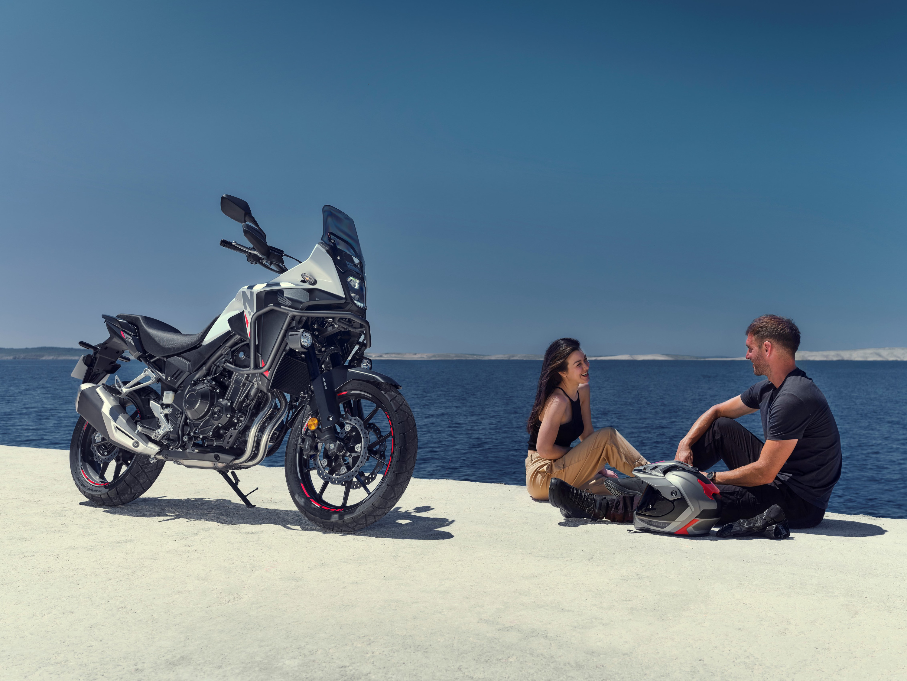Honda NX500 2024 : trois quarts avant droit en bord de mer avec couple