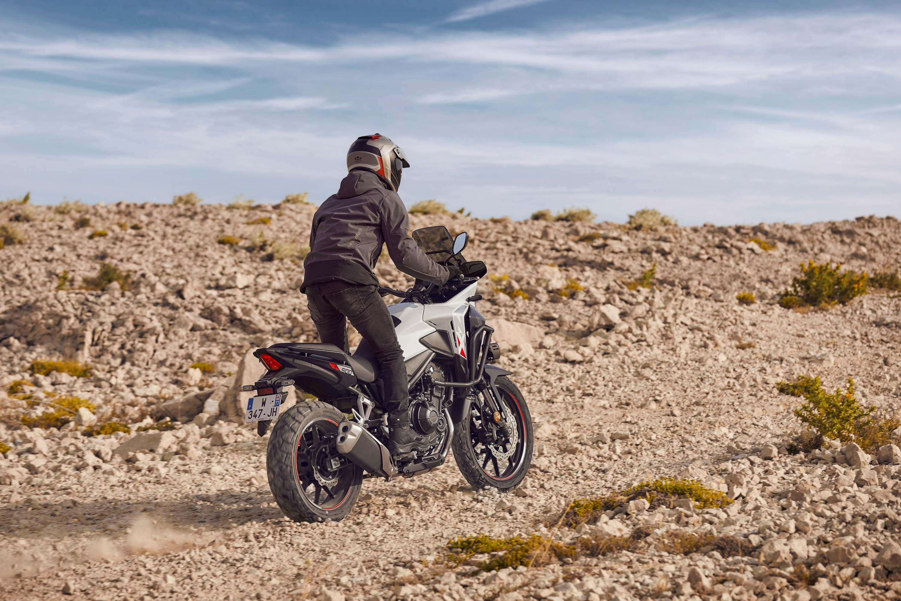 Honda NX500 2024 : trois quarts arrière sur piste de cailloux