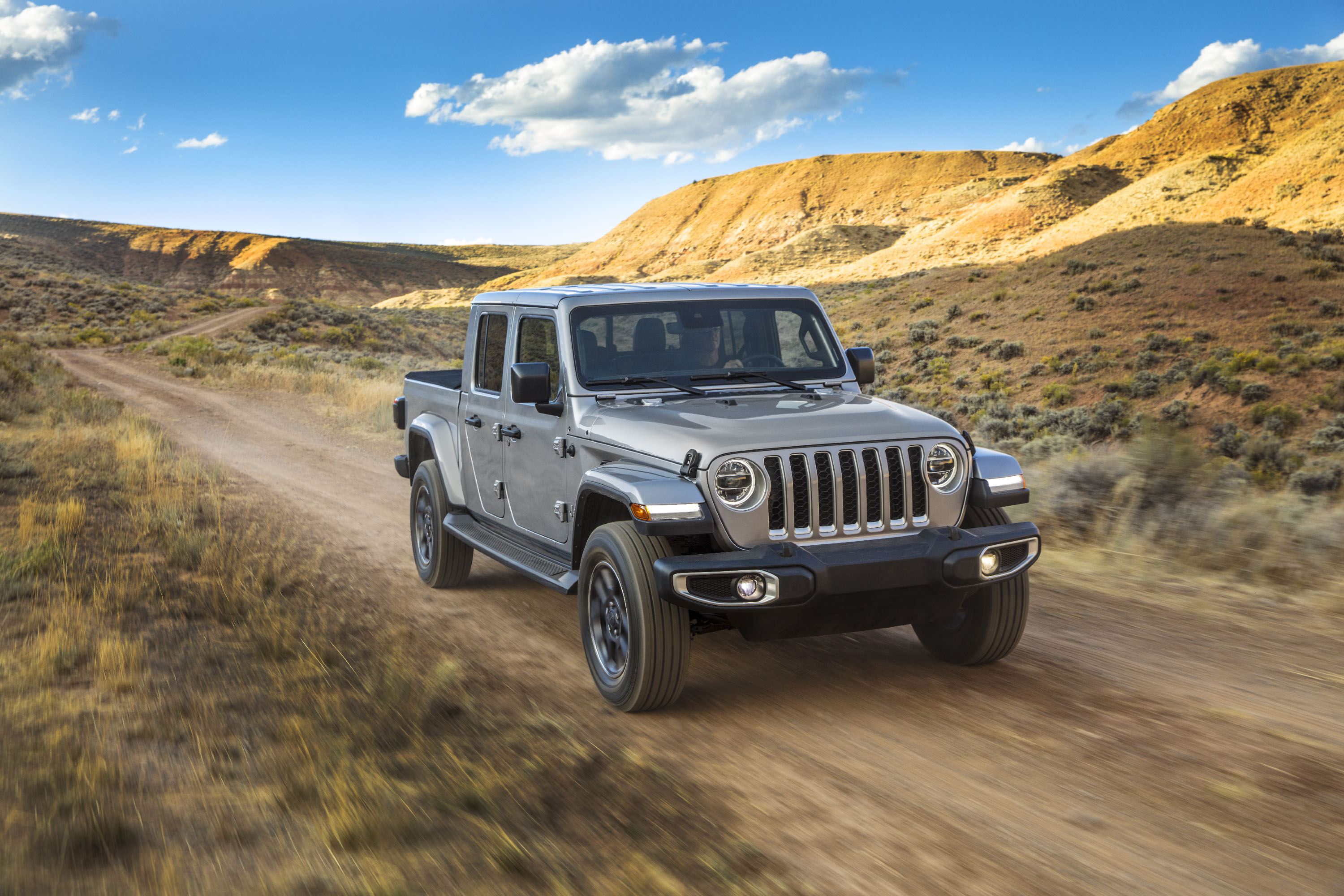 Jeep Gladiator 2022 : Trois quart avant droit roulant sur un chemin