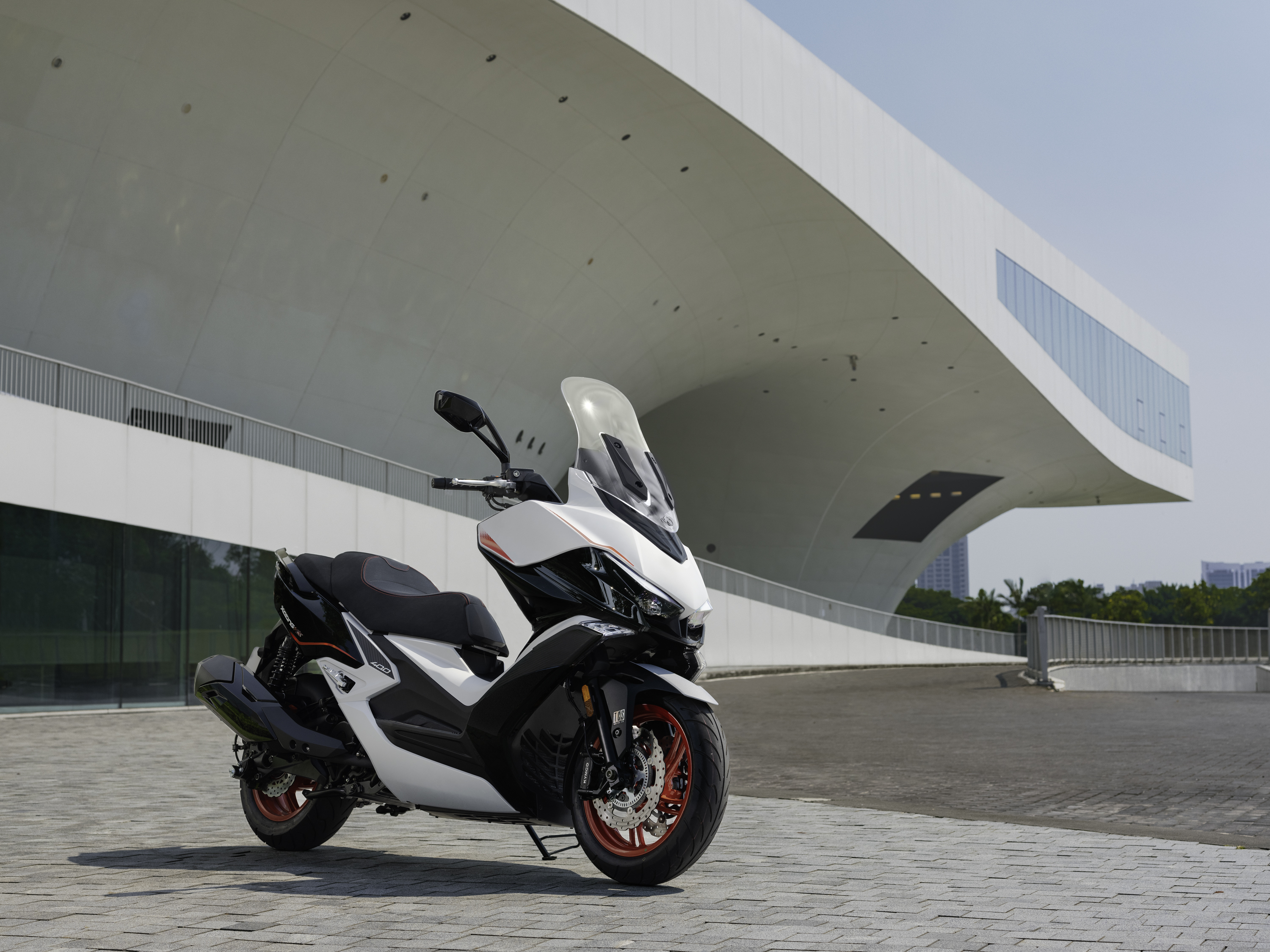 Kymco Xciting VS 400 SE 2024 : toris quarts avant droit statique devant bâtiment