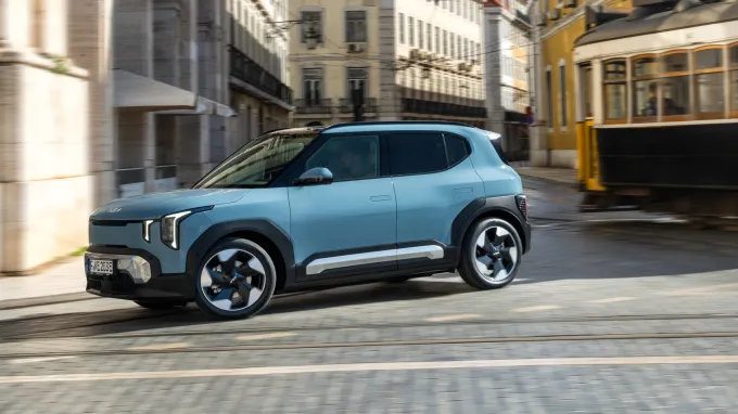 Kia EV2 2026 : profil gauche en ville avec tramway