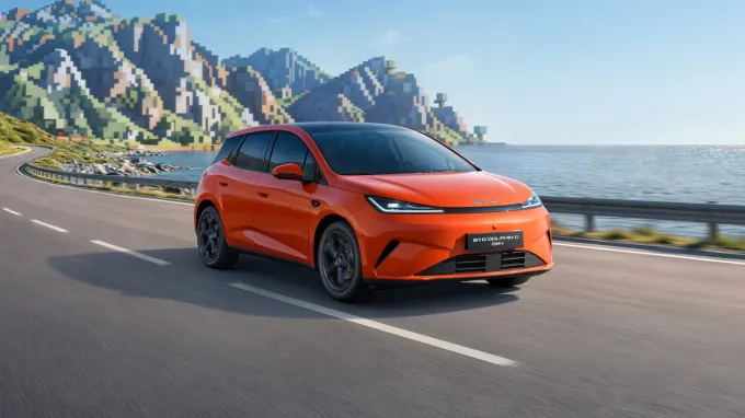 BYD Dolphin G DM-i 2026 : trois quarts avant droit sur route en bord de mer type Minecraft