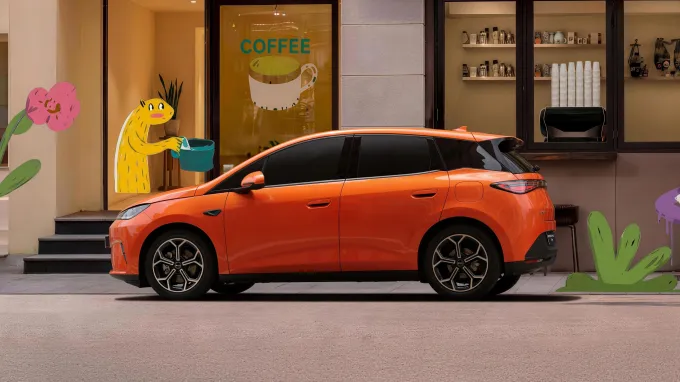 BYD Dolphin G DM-i 2026 : profil gauche statique devant café