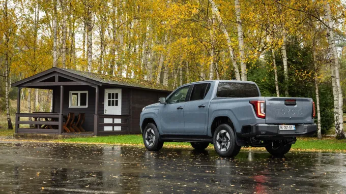 Toyota Hilux : 3/4 arrière devant chalet de forêt