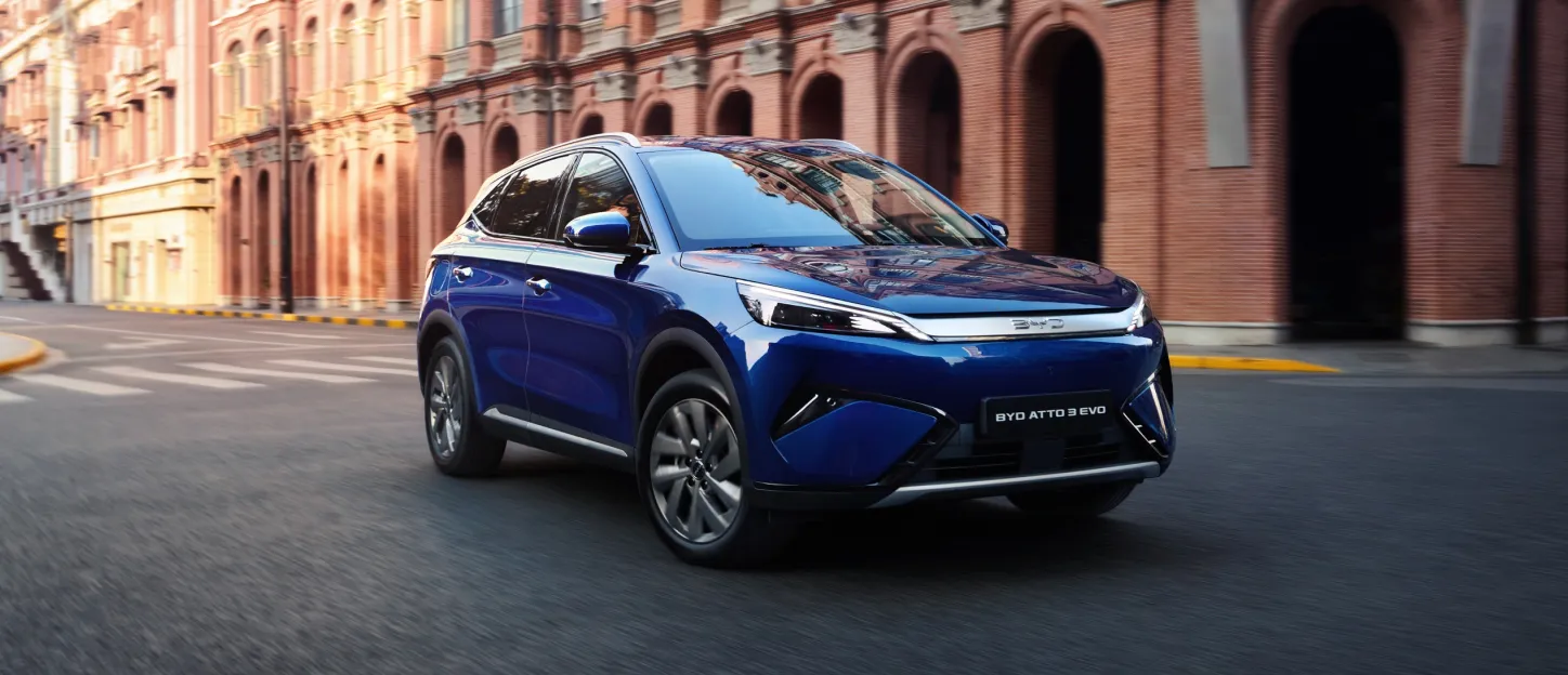 BYD Atto 3 Evo 2026 : trois quarts avant droit devant bâtiment en briques